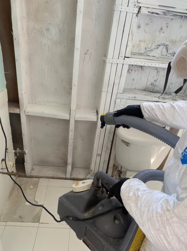 Swift Restoration technician HEPA vacuuming a flood-cut wall cavity during a mold remediation in South Florida